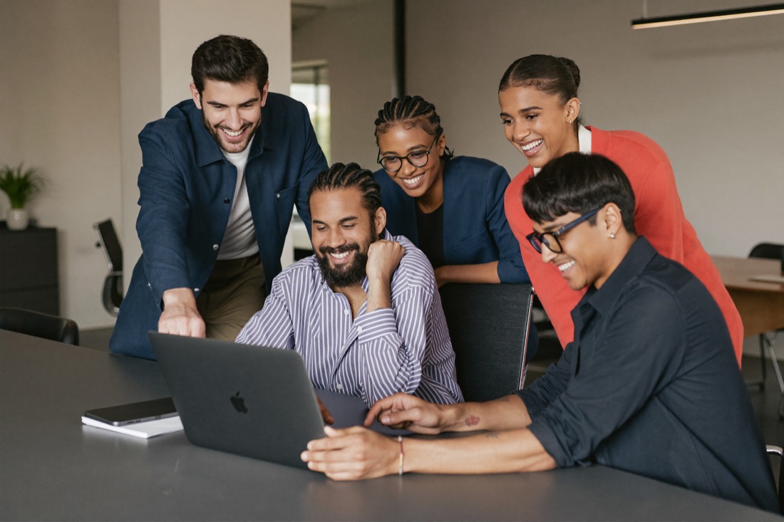 Ein Team arbeitet gemeinsam am Laptop
